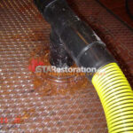 Vacuum hose connected to a floor drying panel