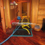 Floor drying equipment in a narrow wood-floored hallway