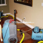 Dehumidifier and air mover beside a wood floor