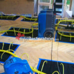 Dehumidifier surrounded by floor drying panels