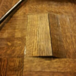 Close-up of raised parquet blocks in a wood floor.