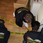 Restoration crew placing yellow caution tape around a work area.