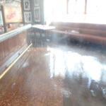 Standing water beside a counter and upholstered bench seating.
