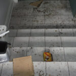 Debris scattered across tiled stairs and a landing.