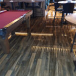 Wet flooring and reflections around a pool table.