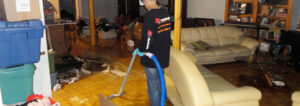 Our Team, Water Damage Restoration Team Technician, is using a vacuum in a room