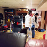 Air movers positioned across wet flooring