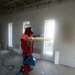 Technician treating smoke residue on wall