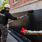 Technician fastens a termination strip above black dimpled foundation membrane.